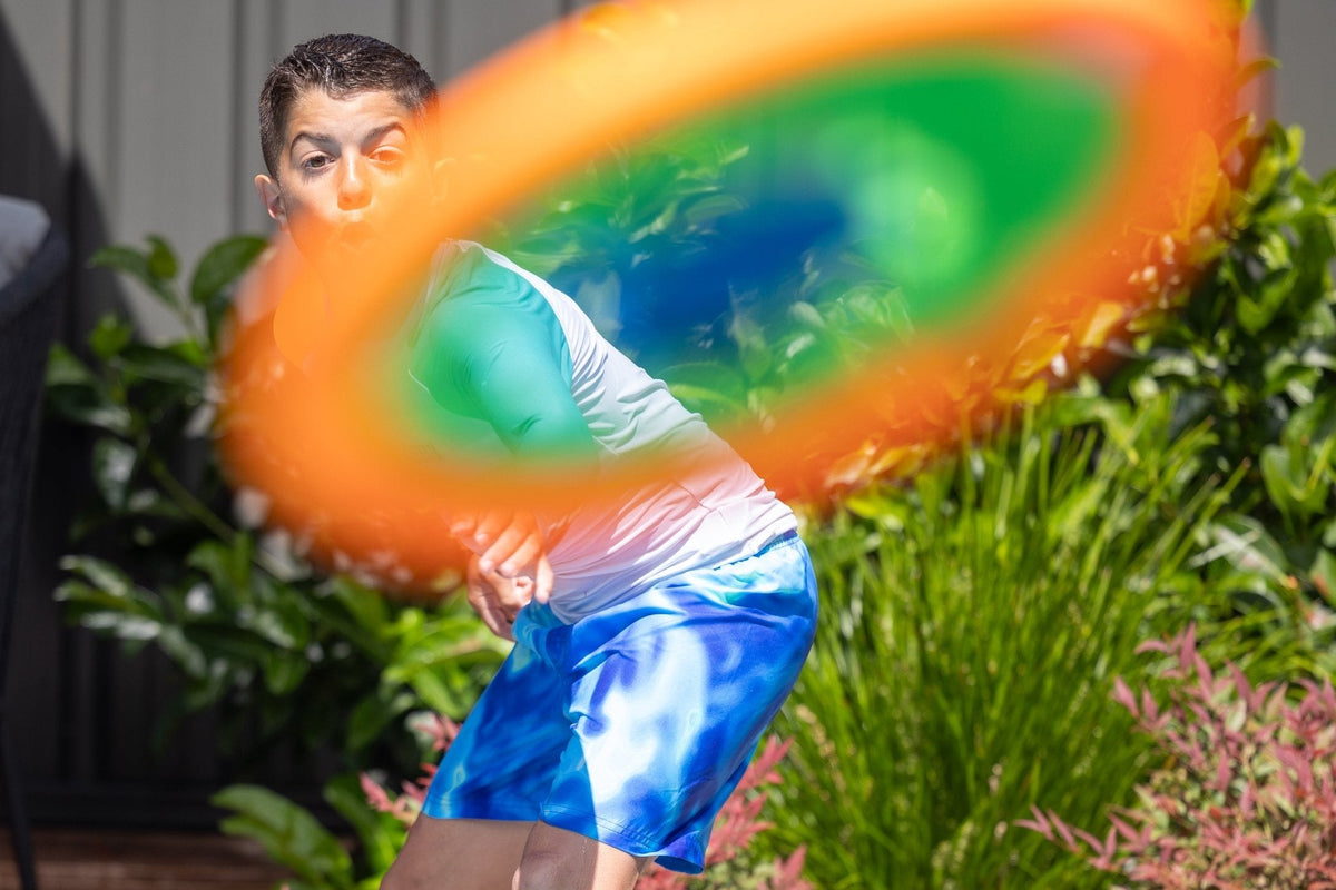 Swimmer holding an orange Aqua Disc above the pool water